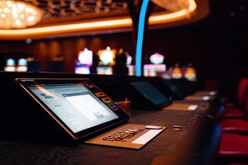 A man celebrating a winning moment on his laptop while gaming symbols float around him, capturing the excitement of 366BET games.